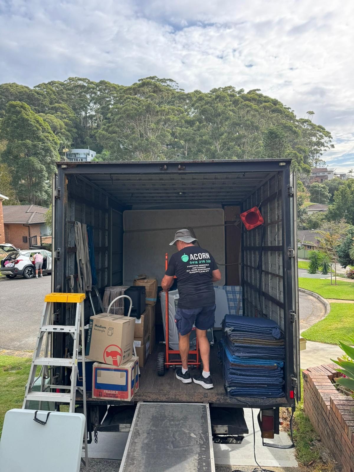 Acorn mover loading furniture and packed boxes into the back of a branded truck on the Central Coast