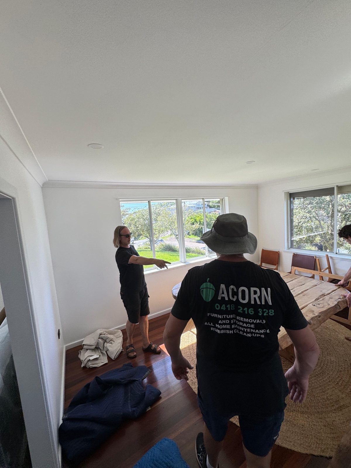 Acorn crew on-site in a Central Coast home with hardwood floors and a Coast view